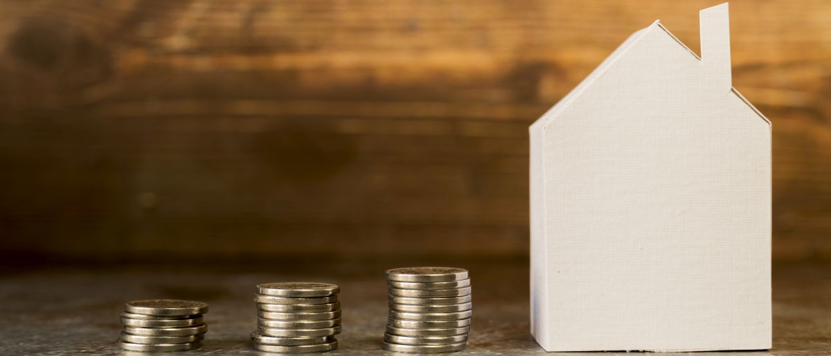 increasing stack coins near paper house surface